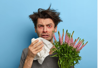 Guy with tissues and allergies sneezing